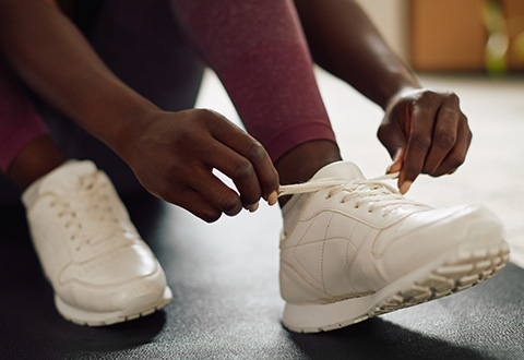 Woman tying up sneakers A woman tying up her sneakers